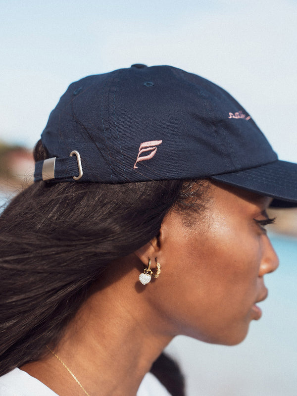 Woman wearing a navy blue Fly Private dad hat